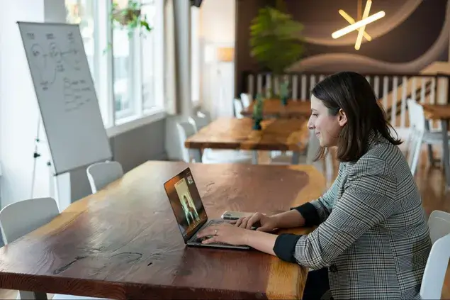 A woman sitting at a desk with a laptop